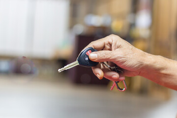 Senior man holding car keys, blurry background