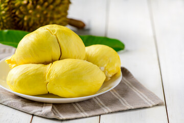 Fresh durian (monthong) on white dish and white wood background,