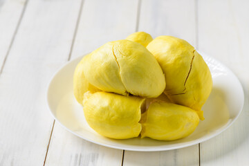 Fresh durian (monthong) on white dish and white wood background,