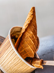 Eiswaffel und Eisbecher im Abfalleimer