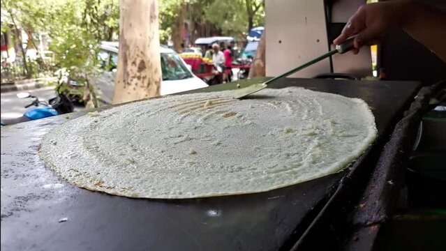 Man making Dosa in India. South Indian dish.