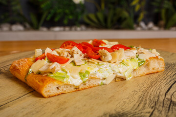 Pizza romana cotta al forno con pollo, insalata, maionese e pomodori servita per pranzo in una rosticceria