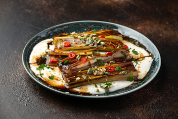 Sweet and sour braised leeks over whipped feta cheese, vegetarian vegan summer Asian style food concept