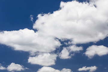 Snow-white light fluffy cloud in a bright blue clear sky
