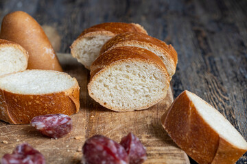 sausage sliced with a baguette on a wooden board