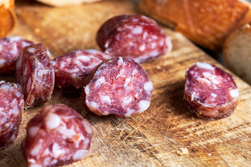 sausage sliced with a baguette on a wooden board