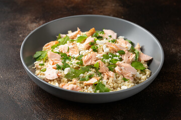 Salmon Couscous salad with feta cheese dressing and herbs. healthy food.
