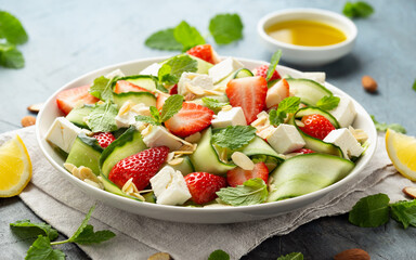 Summer Strawberry, cucumber salad with lettuce, feta cheese and almonds. Healthy Food.