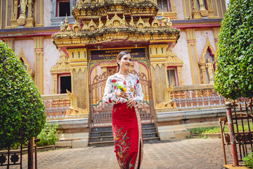 Beautiful Asian girl at big Buddhist temple dressed in traditional costume