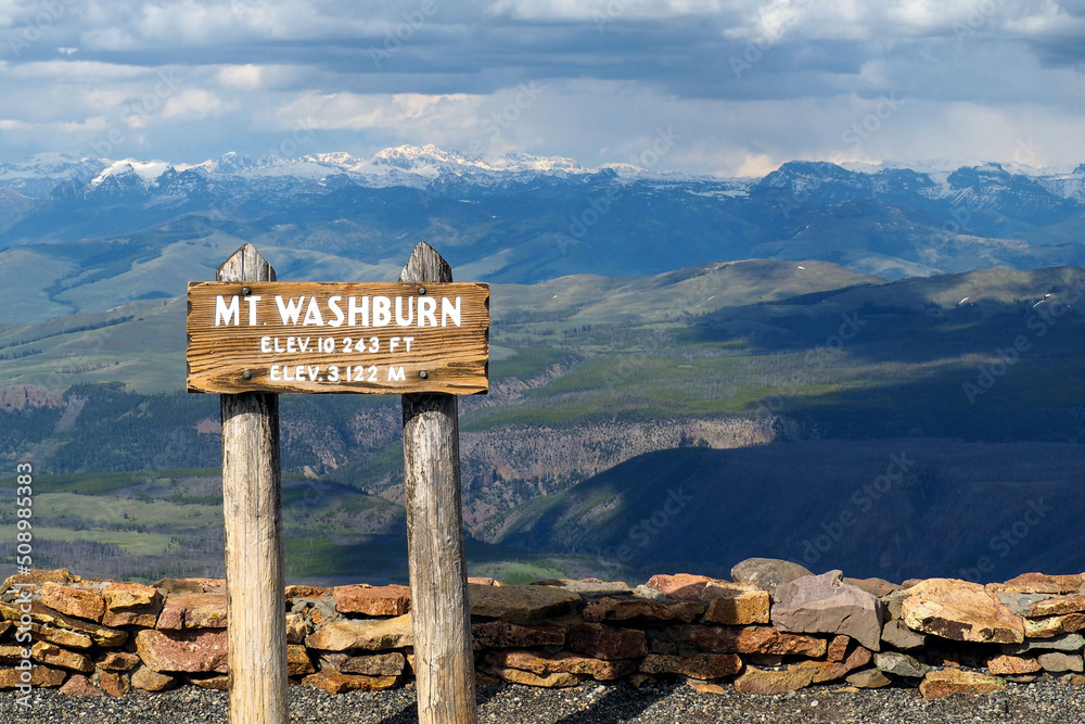 Wall mural Wooden sign on the top of Mt.Washburn in Yellowstone National Park, Wyoming, USA with vast mountain landscape in the back. Nice day hiking in the mountains.