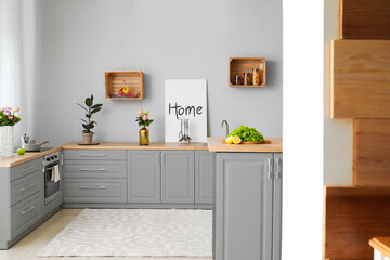 Interior of modern comfortable kitchen with grey furniture