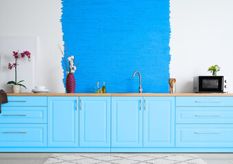 Stylish interior of modern kitchen with blue furniture