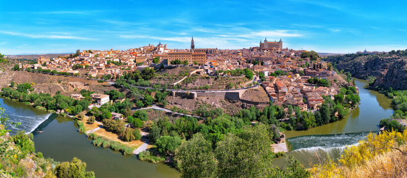 Picturesque panorama of the ancient city of Toledo on the banks of the Tagus River on a sunny afternoon against the blue sky. Capital of the province of Toledo, community of Castilla–La Mancha, Spain