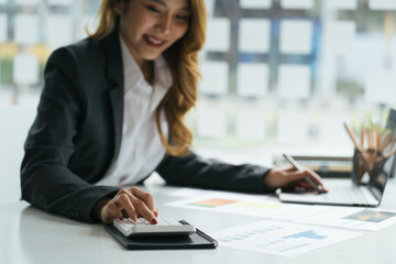businessman working on desk office with using a calculator to calculate the numbers, finance accounting concept