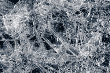 Natural background of ice crystals randomly covering a dark surface