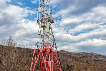 Cell tower on the mountain, against a cloudy sky