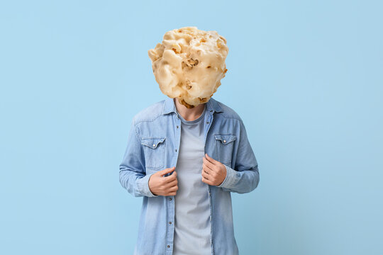 Man with tasty popcorn ball instead of his head on light blue background