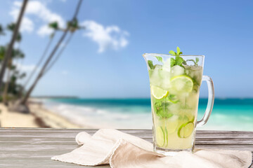Jug of fresh mojito on table at tropical resort