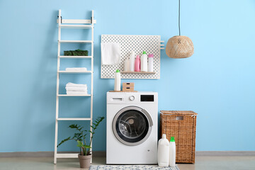 Interior of laundry with modern washer near color wall - obrazy, fototapety, plakaty