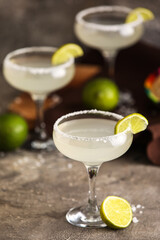 Glasses of tasty margarita cocktail on grunge background, closeup