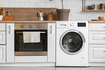 Stylish interior of kitchen with modern washing machine