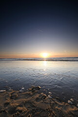 Long exposure, of the sea with orange sunset, Shells in the sand. Abstract view