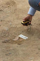 An archaeologist at field work recording a pottery find with a GPS