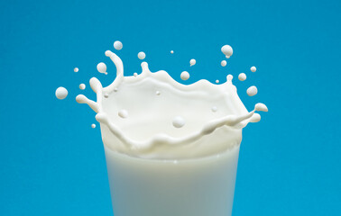 Milk splash in shape of crown in milk glass isolated on blue background.