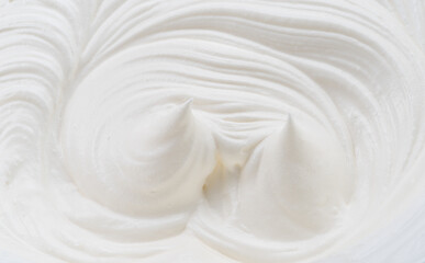Creamy pics and swirls in yoghurt or cream surface. Top view.