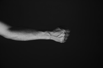 Brutal mans hand with protruding veins, black background.Black and white photo.