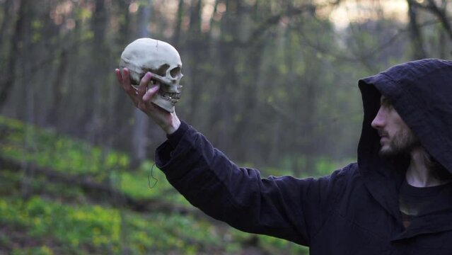 a monk in a hood with a skull