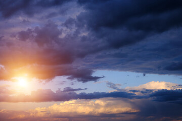 Naklejka na ściany i meble Thunderclouds with breaking rays sun at sunset.