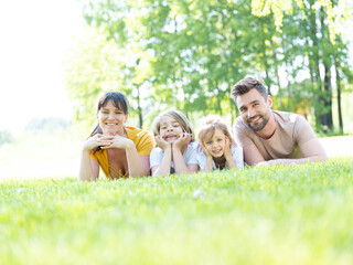 Family of four laying on grass