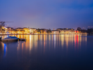 Lugano city on the lake illuminated at night in Switzerland