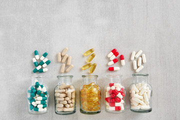 Five glass bottles of supplements pills. Variety of nutritional supplements and vitamin capsules. Top view. Flat lay.