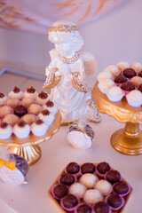 a table decorated with sweets, a cake, arrangements and the words: Faith