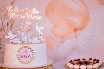 A baby on top of a cake with birds and clouds around it, and the words: Maria Vitoria.