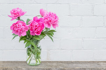 bouquet of peony flowers on a white wall background