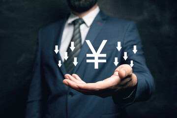 Yen icon with down arrows. The fall of the currency. Man holding in his hand