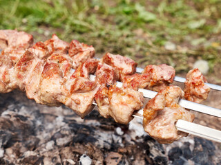 Cooking meat skewers on an open fire. Summer vacation outside the city.