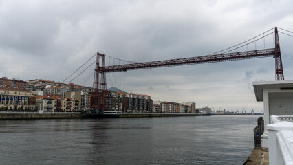bizkaia suspension bridge with metal structure considered world heritage for transport with cloudy sky crossing the river in spring day