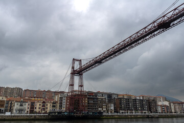 Fototapeta na wymiar bizkaia suspension bridge with metal structure considered world heritage for transport with cloudy sky crossing the river in spring day