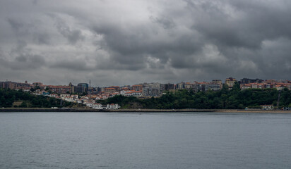 Obraz premium coastal town with calm sea from the beach on a cloudy spring day