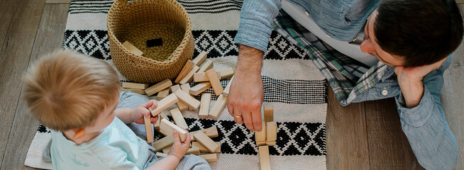 Long banner for design, web page. Father and toddler boy child little son playing with wooden blocks