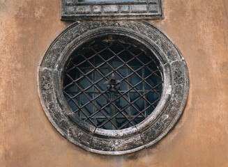 Large vintage round window with bars on the Boim Chapel in Lviv, Ukraine. Decorative element of an old renaissance building.