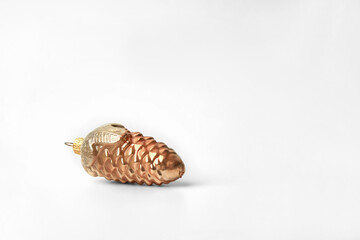 An old Christmas tree toy is a gilded glass cone on a white background. Copy space.