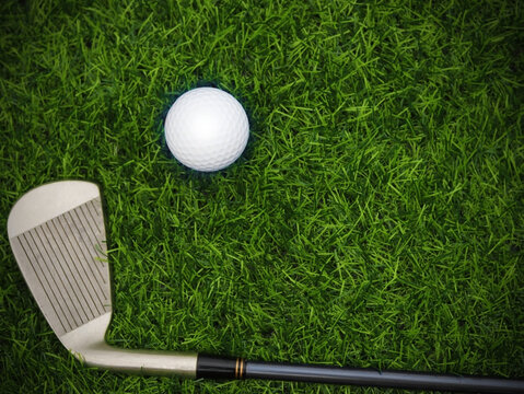 Golf club top view on green grass on blurred beautiful landscape of golf background.Concept international sport that rely on precision skills for health relaxation..