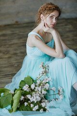 Fototapeta na wymiar girl with a beautiful bouquet of flowers in a blue dress
