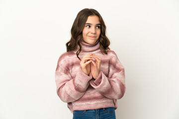 Little caucasian girl isolated on white background scheming something
