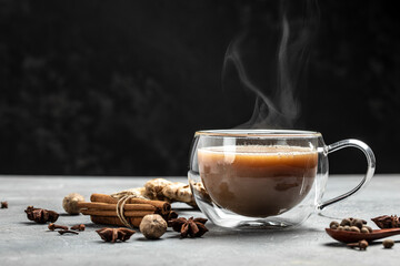 Indian masala chai tea. Hot masala chai spiced tea with milk and spices is poured into a glass...
